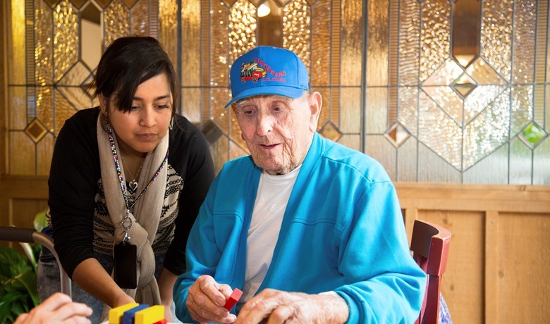 A caretaker helps Alzheimer’s patients