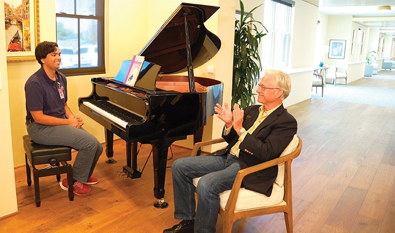 Young boy playing piano for dementia patients