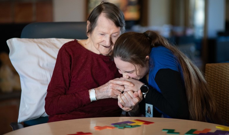 Caretaker kissing patients hand