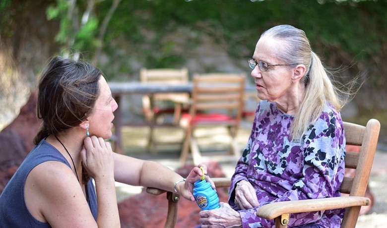 Caregiver talking to patient sitting in chair