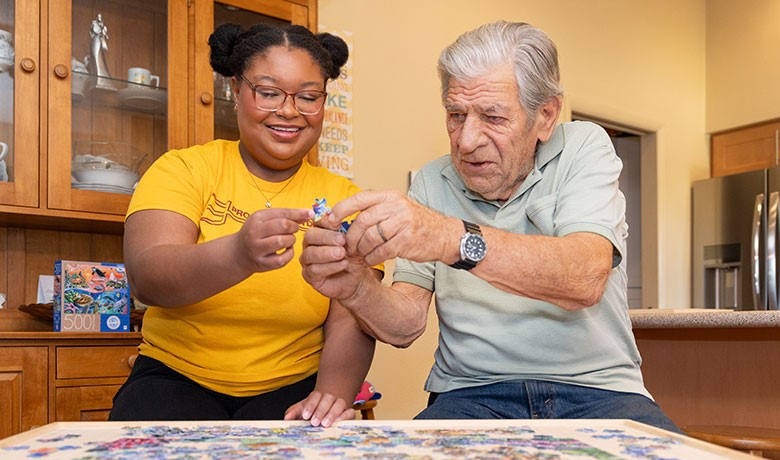 Emily-Jane Crawford and patient Bud Addison doing a puzzle