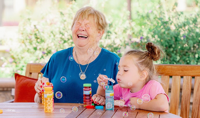 Dementia patient with child blowing bubbles